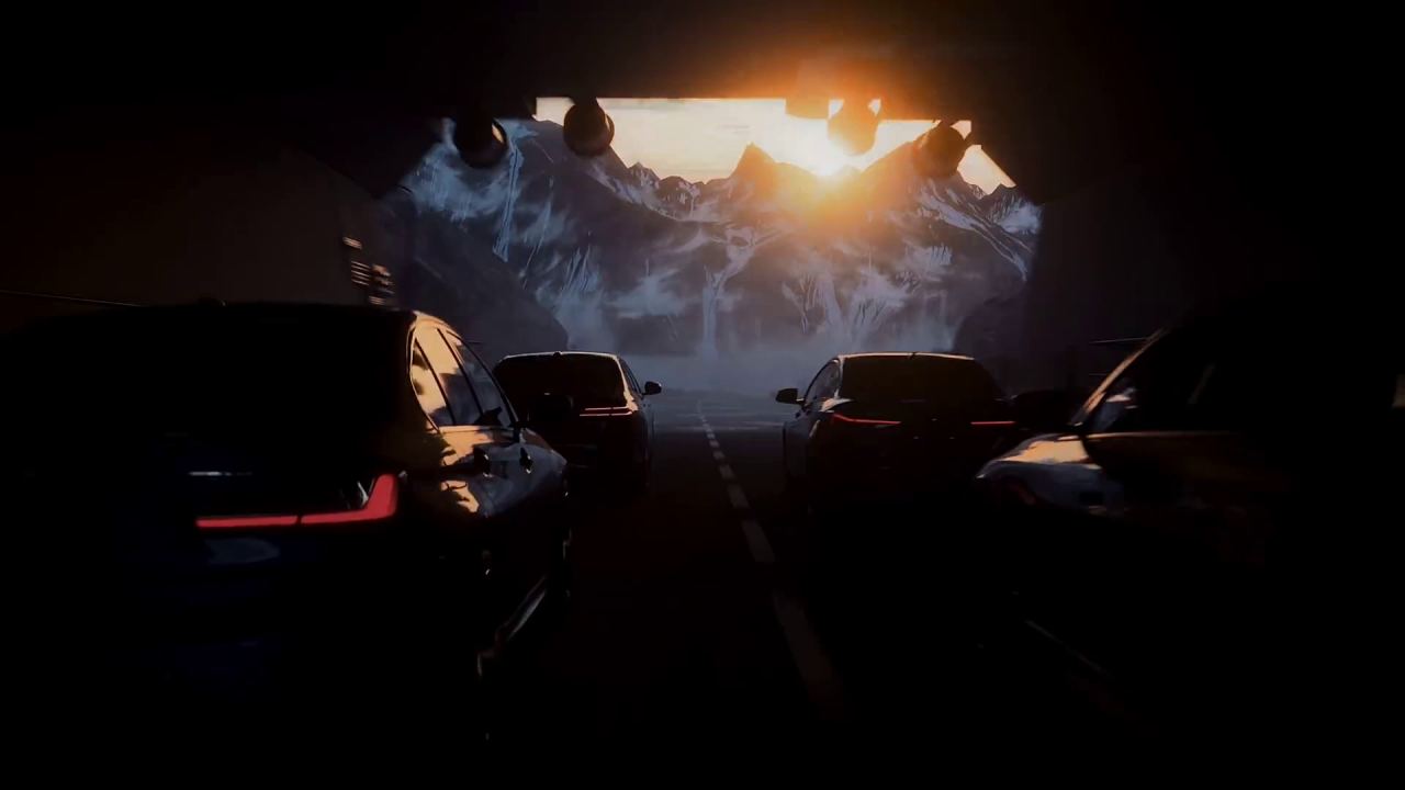 Cars driving along a mountain road at sunset